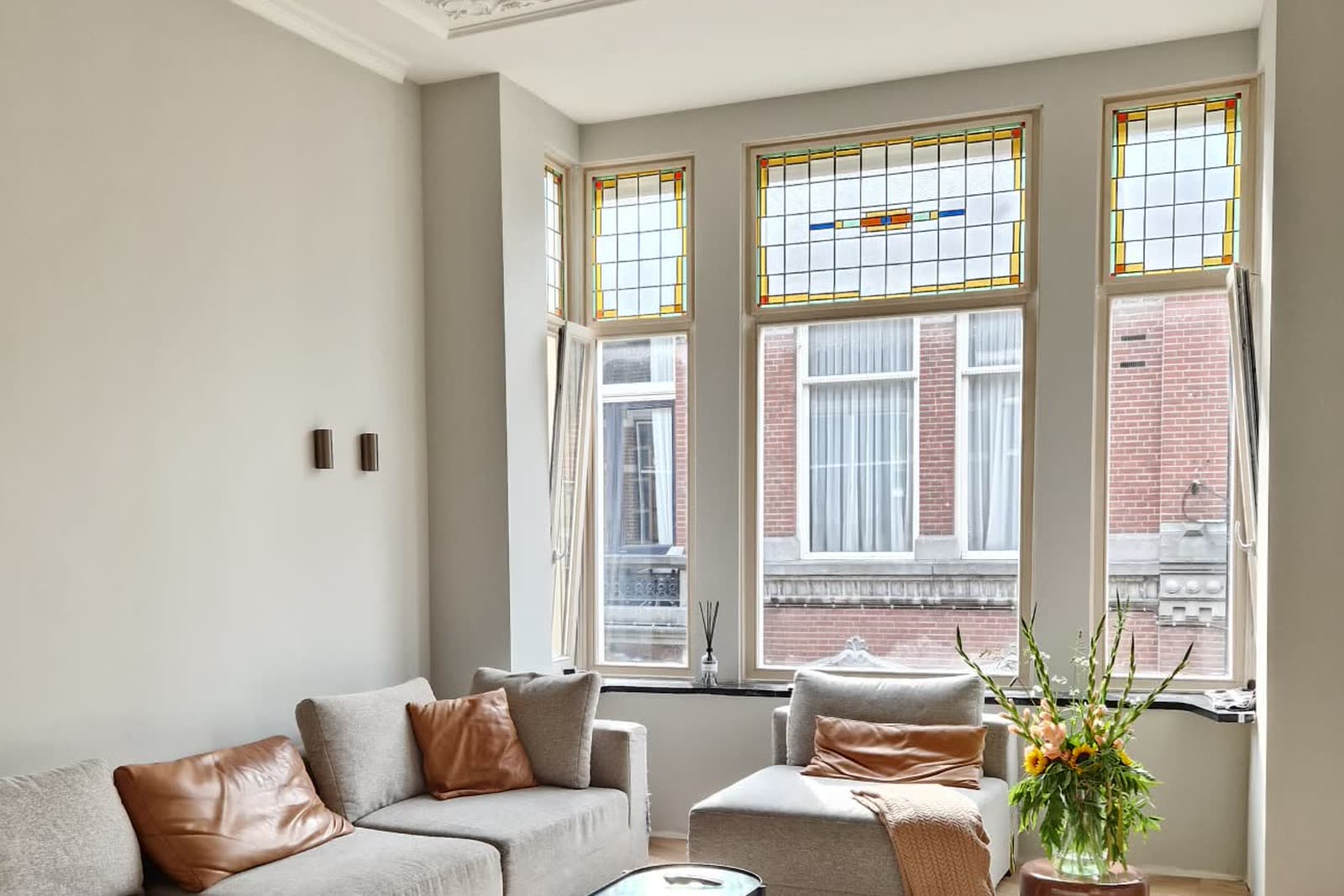 De salon na oplevering, met herstelde erker en glas-in-lood