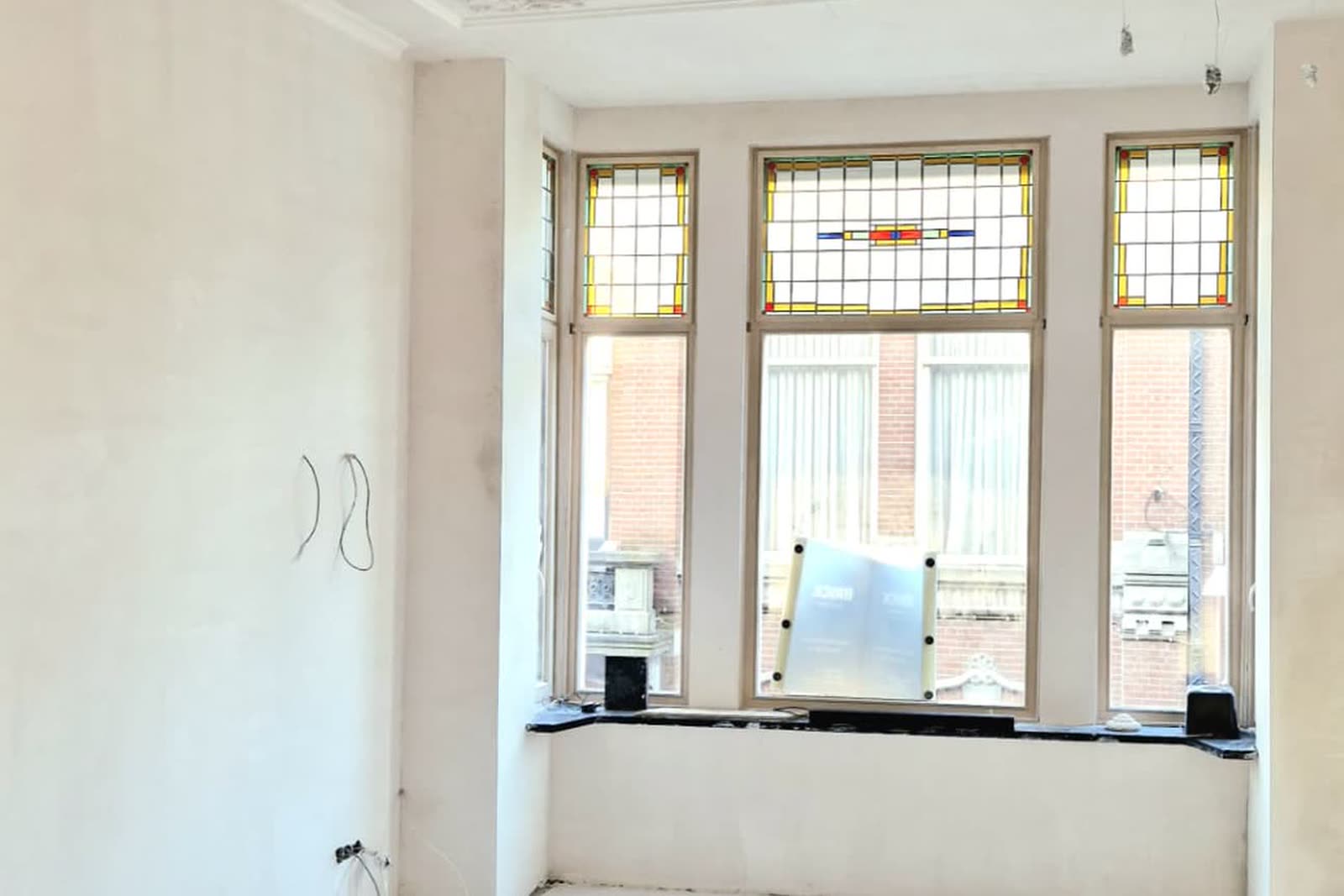 Dezelfde salon tijdens de verbouwing, gestript tot op de kale wanden