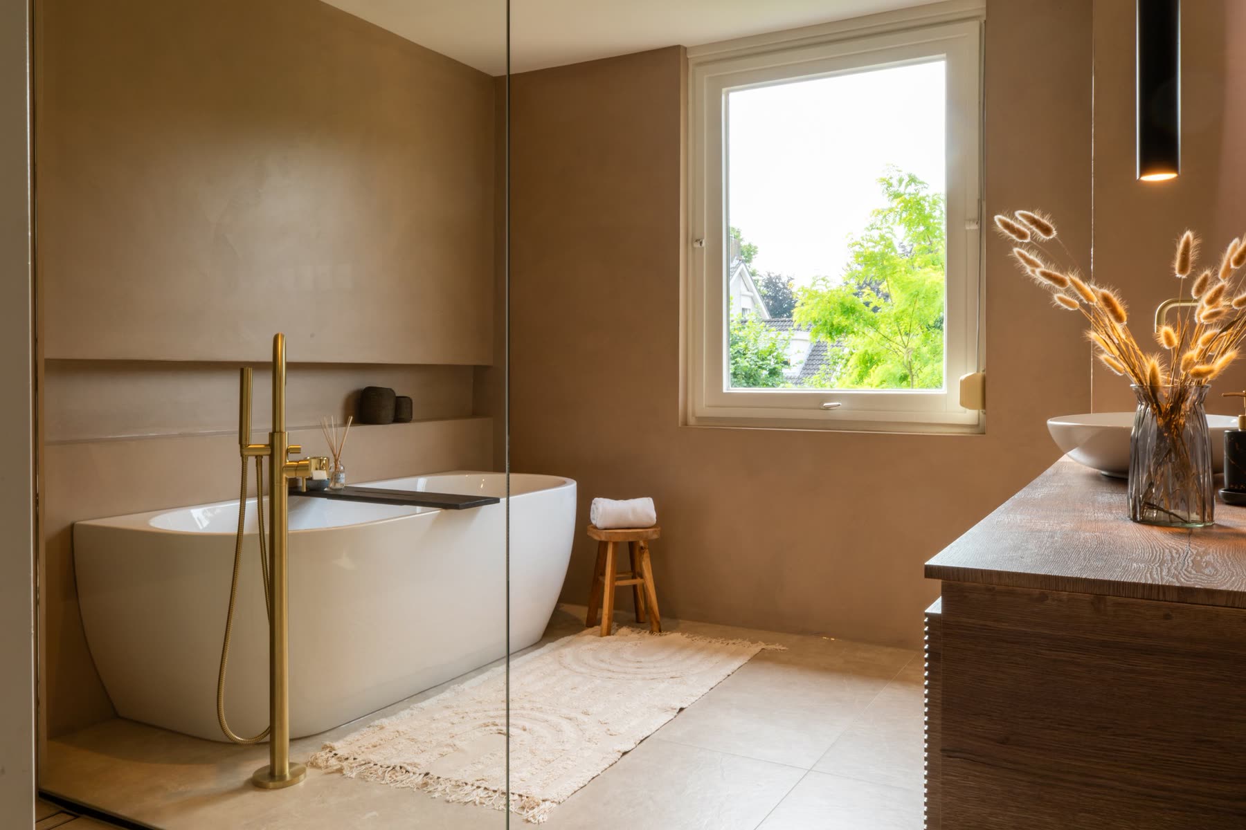 Badkamer met vrijstaand bad en messing kraanwerk