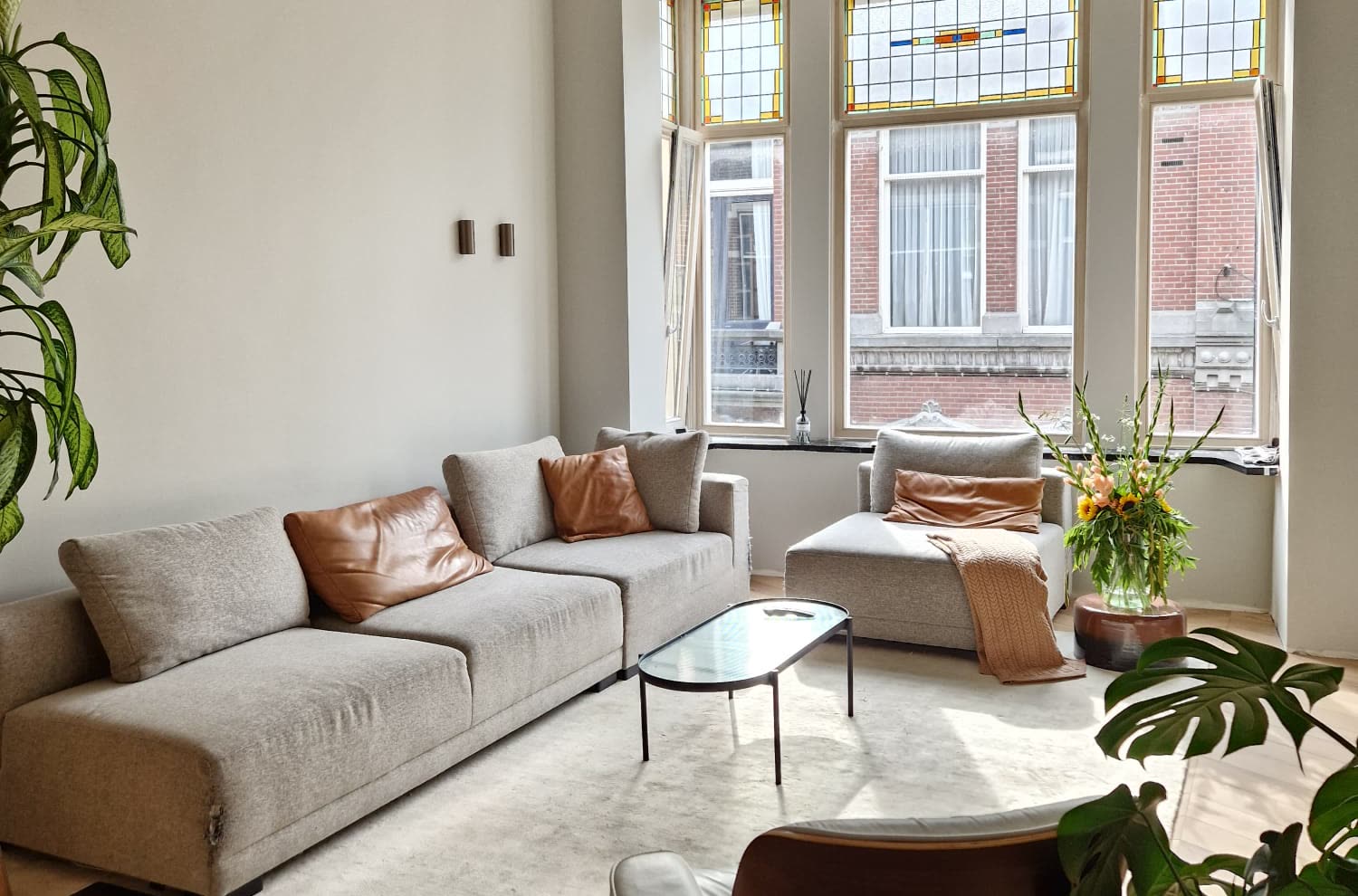 Salon van een gerestaureerd herenhuis met glas-in-lood en plafondornament