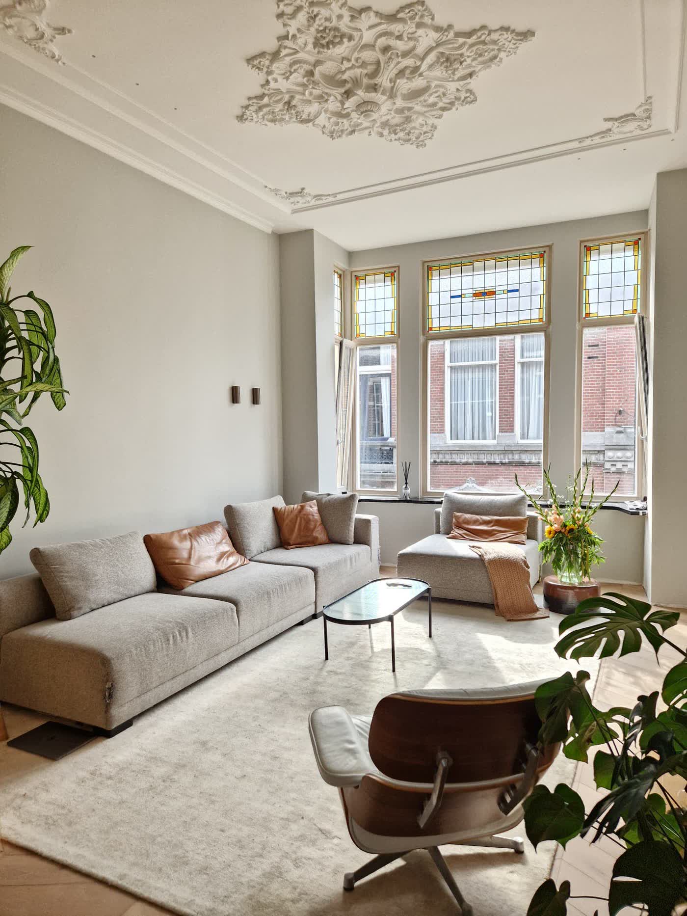 Salon van een gerestaureerd herenhuis met glas-in-lood en plafondornament